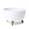 A white bowl-shaped planter with three wooden legs, shown against a white background. Náhled obrázku produktu