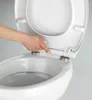 A hand is shown pressing a button on a toilet seat hinge. Produktbild-Vorschau