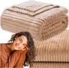 A woman smiling and resting her head on her hands, with a folded beige blanket in the background and a close-up of the blanket texture in the lower right corner. Anteprima dell’immagine prodotto