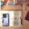 A phone case is shown on an open book, with other items in the background. Produktbild-Vorschau