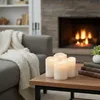 A cozy living room scene with a fireplace, sofa, and a coffee table with LED candles. Produktbild-Vorschau