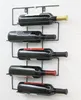 A black metal wine rack mounted on a white wall, holding five bottles of wine. Náhľad obrázku produktu