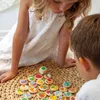 Two children playing a board game with colorful tokens and a die. Anteprima dell’immagine prodotto
