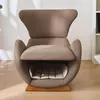 A brown armchair with a built-in pet bed is shown in a well-lit room with wooden flooring and shadows cast on the wall. Náhľad obrázku produktu