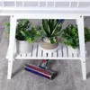A white wooden plant stand with two shelves, holding several potted plants. A vacuum cleaner head is visible underneath the stand. Produktbild-Vorschau