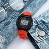 A digital watch with an orange strap is placed on a denim jacket next to a pair of glasses. Anteprima dell’immagine prodotto
