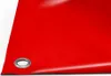 A close-up view of a red PVC truck tarp with a metal grommet. Voir les images du produit