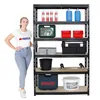 A woman stands next to a black metal shelving unit filled with various items, including tools, containers, and bottles. Produktbild-Vorschau