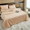 A cozy bedroom scene with a plush blanket draped over a bed. Produktbild-Vorschau