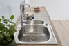 A stainless steel kitchen sink with a faucet, soap, and a small bowl of strawberries on a wooden countertop. Produktbild-Vorschau