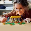 A young girl is playing with a LEGO Minecraft horse stable set. Podgląd zdjęcia produktu