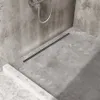 A modern concrete shower with a black linear drain. Produktbild-Vorschau