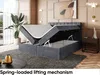 A bedroom scene featuring a lifted bed revealing storage space, with decorative elements and a plant. Produktbild-Vorschau