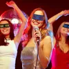 Three women wearing LED glasses at a party, one singing into a microphone. Podgląd zdjęcia produktu