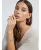A woman wearing jewelry, including hoop earrings, a necklace, and a bracelet. Náhled obrázku produktu