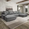 A modern living room with a large U-shaped sofa, a painting on the wall, and wooden beams on the ceiling.