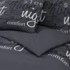 A close-up view of a dark gray bedding set with white text printed on it. Voir les images du produit