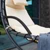 Close-up of a hanging lounge chair with beige cushions and a blue blanket draped over the armrest. Voir les images du produit
