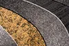 A close-up abstract view of a rug with curved patterns in gray, black, and yellow. Anteprima dell’immagine prodotto