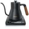 A black electric kettle with a wooden handle sits on its charging base, which has a digital display. Náhled obrázku produktu