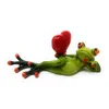 A ceramic figurine of a green frog lying down and holding a red heart. Produktbild-Vorschau