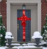 A decorated front door during winter, with snow on the steps and urns. Náhled obrázku produktu