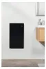 A black electric heater mounted on a white wall in a bathroom, next to a wooden vanity with a sink and mirror. Náhled obrázku produktu