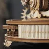 A close-up view of a wooden mechanical model, likely a globe, showing intricate gears and decorative elements. Náhľad obrázku produktu
