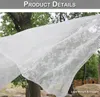 A white lace curtain is blowing in the wind outdoors, with trees and rocks in the background. Produktbild-Vorschau