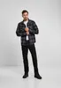 A man is standing and posing in a studio setting. Produktbild-Vorschau