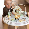 A baby is playing with a wooden activity table with animal-themed toys. Produktbild-Vorschau