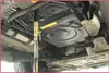 Underneath a vehicle, a fluid transfer system is being used to fill or drain a transmission. Náhľad obrázku produktu