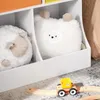 A close-up view of a white toy storage unit with two plush toys inside and a toy train on the floor. Anteprima dell’immagine prodotto
