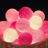 A close-up view of a basket filled with decorative string lights in various shades of pink and white. Produktbild-Vorschau