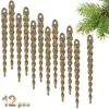 A collection of gold glittery icicle ornaments arranged in a cascading pattern, with a hint of a green pine branch in the upper right corner. Anteprima dell’immagine prodotto