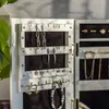 A close-up view of an open jewelry box, showcasing various earrings and a bracelet. Produktbild-Vorschau