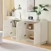 A white sideboard with its doors open, displaying shelves with books, a basket, and a jar. The top surface holds a lamp, a statue, a vintage radio, and a vase with a plant. Anteprima dell’immagine prodotto
