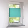 A turquoise pleated blind is installed on a white window frame. Produktbild-Vorschau