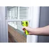 A hand holding a yellow infrared thermometer is pointed at a window frame. Produktbild-Vorschau