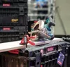 A close-up shot of a circular saw and a clamp on top of storage containers. Podgląd zdjęcia produktu