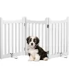 A puppy sits in front of a white wooden pet gate. Podgląd zdjęcia produktu