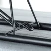 A close-up view of the black metal frame of a small ironing board, showing a hook-like connection point. Voir les images du produit