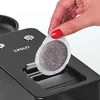 A hand is inserting a coffee pod into a coffee machine. Náhľad obrázku produktu