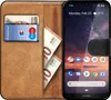A book-style phone case with cards and cash inside, next to a smartphone. Náhled obrázku produktu