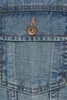 A close-up of a denim jacket pocket with a button. Produktbild-Vorschau