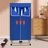 A blue foldable clothes drying rack with wheels and a remote control is shown in a room with wooden furniture. Náhled obrázku produktu