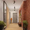 A modern hallway with brick walls, wooden floors, and a large mirror. Podgląd zdjęcia produktu
