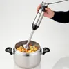 A hand holding a silver and black immersion blender over a pot of chopped vegetables. Anteprima dell’immagine prodotto