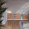 A modern living room with a modular storage unit against a wall, featuring wood-effect doors and white frames. A large potted plant is in the foreground. Voir les images du produit