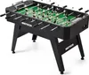A black foosball table with green playing field and white and black player figures, shown from a slightly elevated side angle. Náhled obrázku produktu
